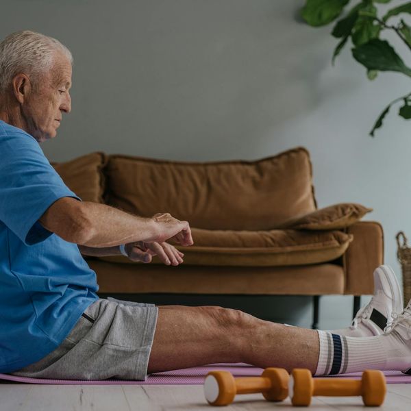 Person sitting calmly and stretching after a workout, feeling refreshed.