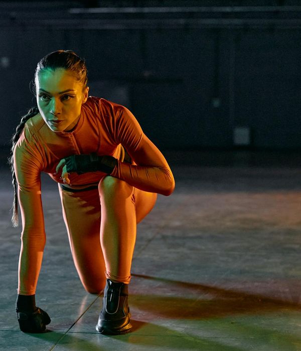 Woman performing a dynamic cardio exercise in a modern studio.